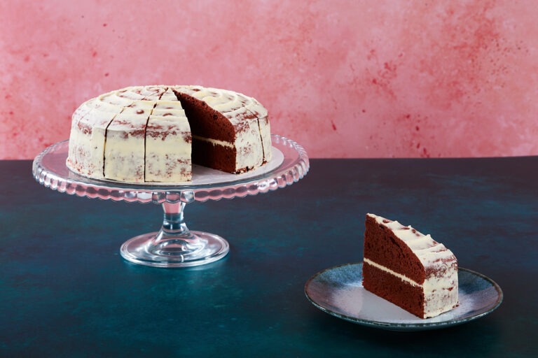 Red velvet cake with cream cheese frosting and red velvet crumbs.
